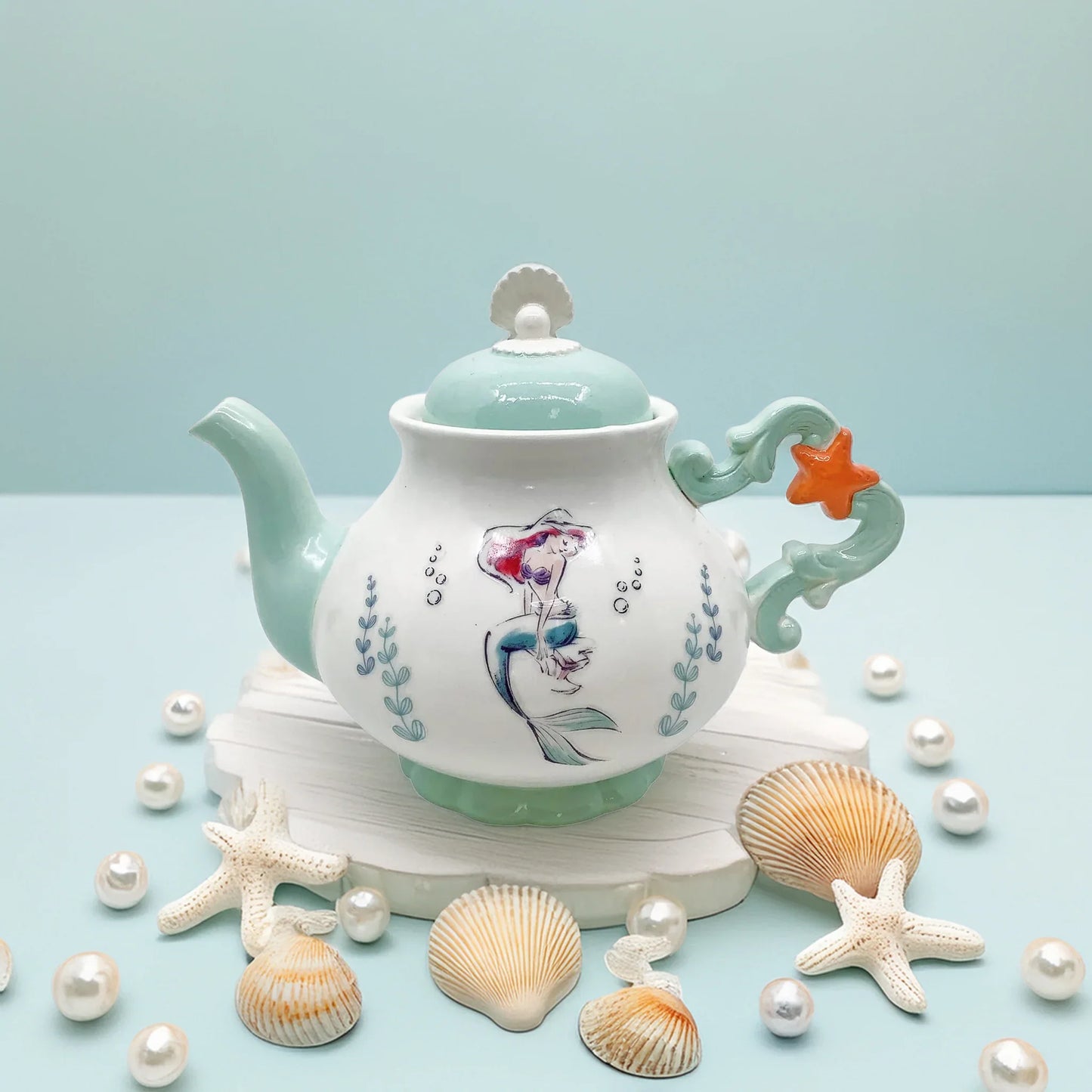 Disney Ariel Teapot front view – The Little Mermaid porcelain teapot featuring Ariel with flowing red hair, surrounded by sea motifs and ocean colors, collectible gift for Disney Princess fans