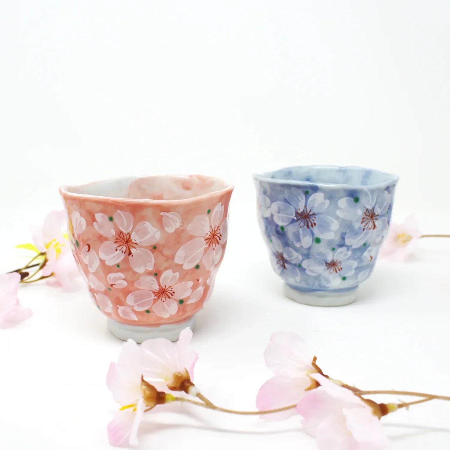 Side view of pink and blue Yayoihana Mino Ware Yunomi Teacup in soft pink and blue with white cherry blossom flowers, handcrafted in Japan