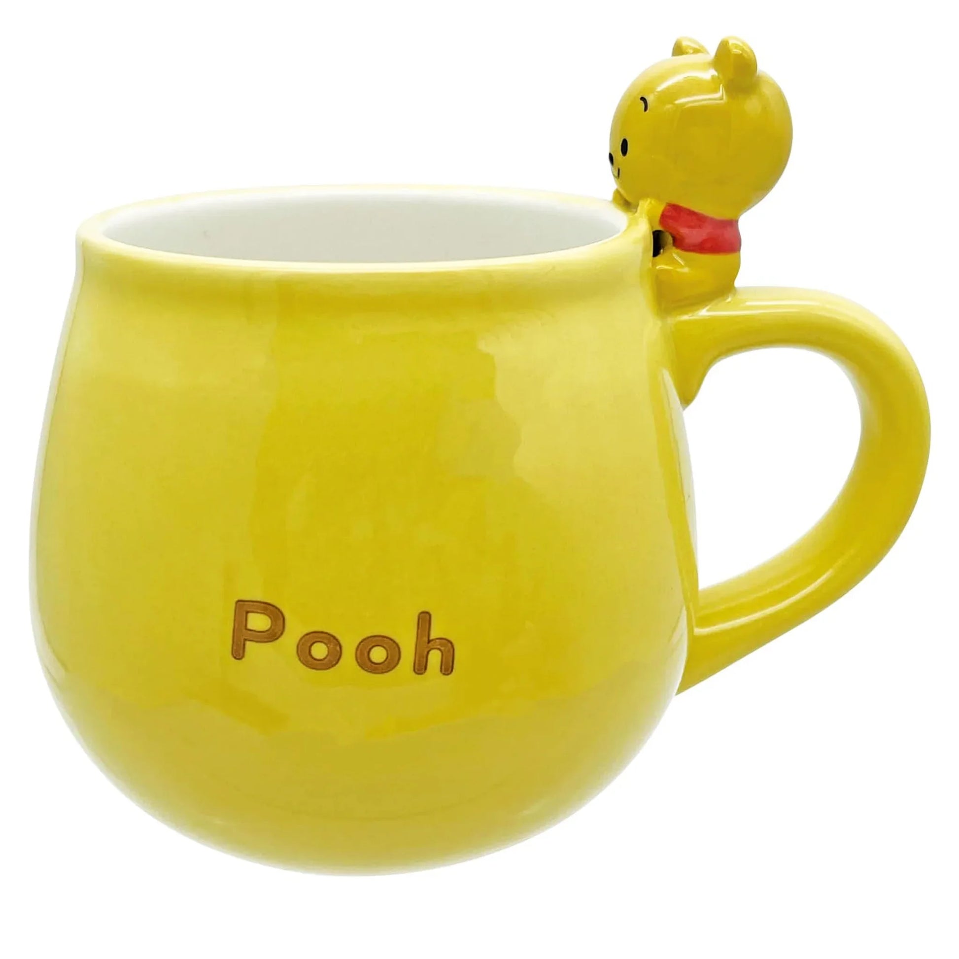 Yellow mug with a small Winnie the pooh figure on top and 'Pooh' text, on a white background