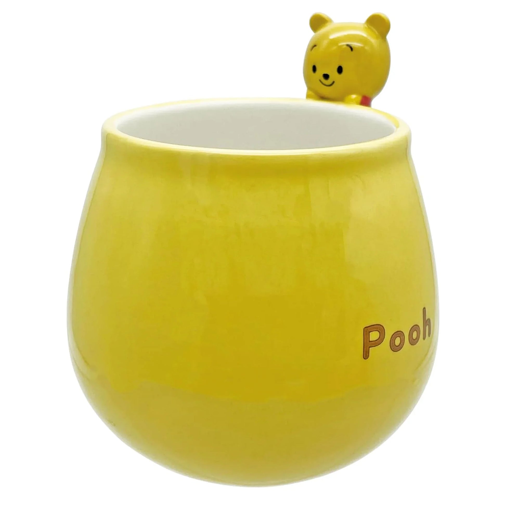 Yellow mug with a small Winnie the pooh figure on top and 'Pooh' text.