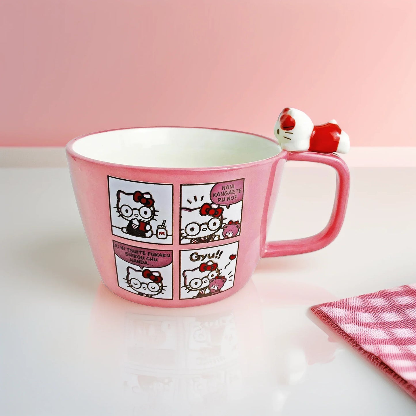 Pink mug with Hello Kitty character design on a white surface with a pink background