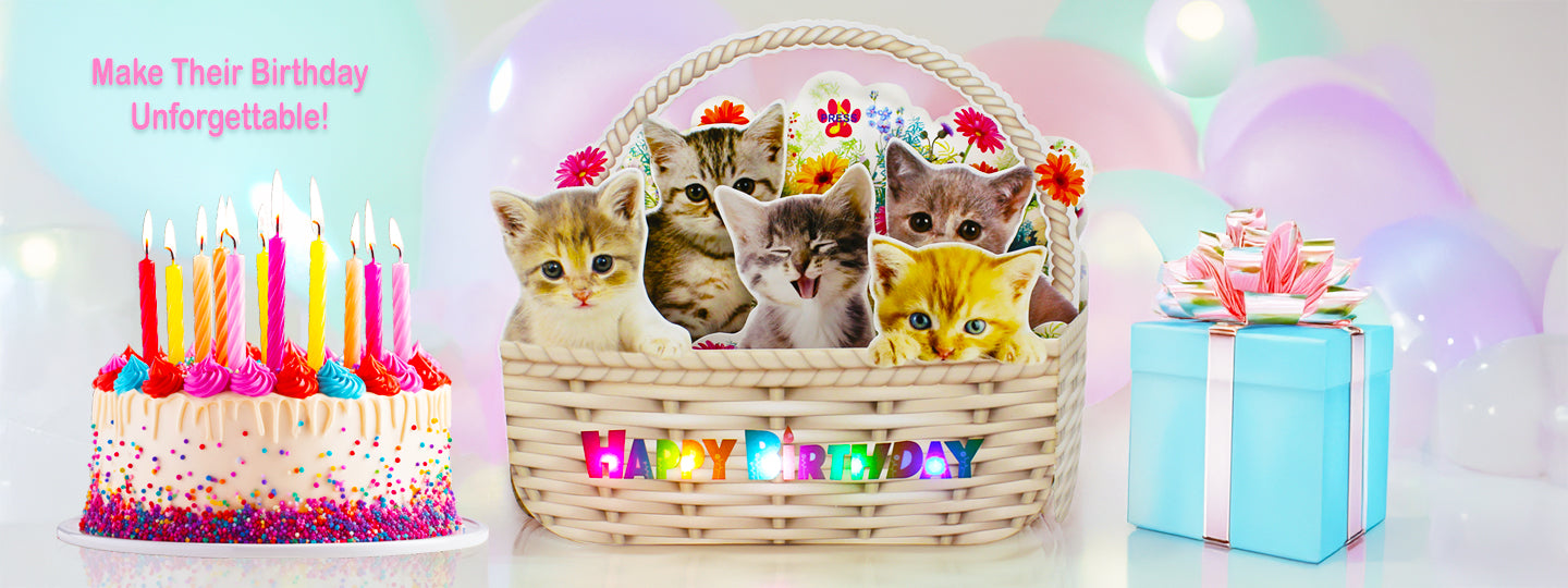 Three kittens in a basket lights and musical pop up card with birthday decorations, including candles and a cake, on a light pink background.