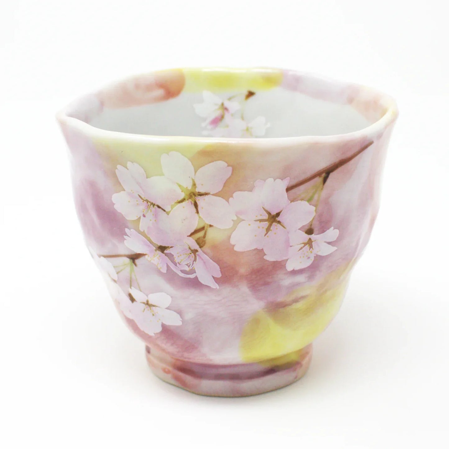 Side view of Hanagasumi Mino Ware Yunomi teacup featuring soft pink and yellow hues with delicate cherry blossom branches, made in Japan.