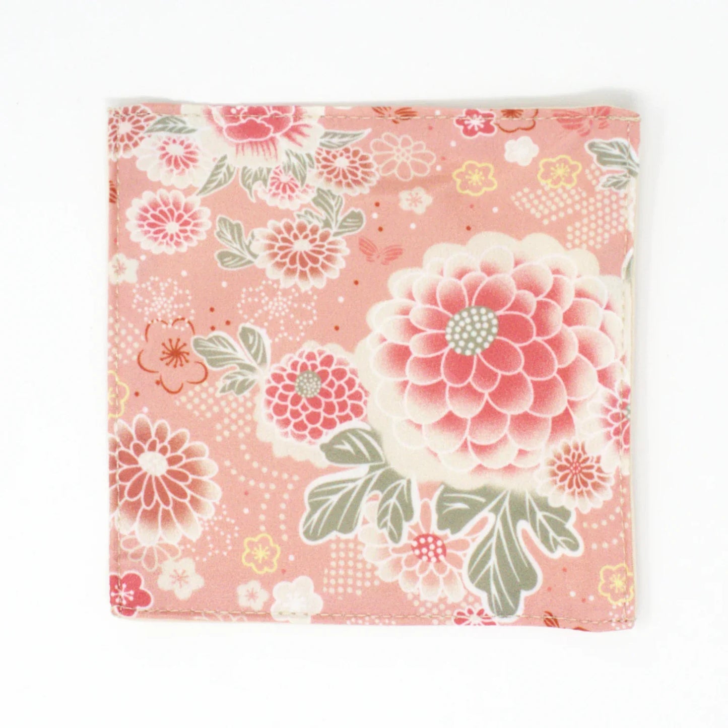 Chirimen fabric coaster with delicate cherry blossom floral pattern in soft pink and white tones, handcrafted in Japan with a textured, traditional weave for an elegant tea-time accessory.