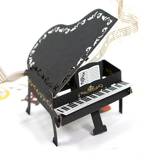 Miniature black piano pop up card with music sheet on a white background