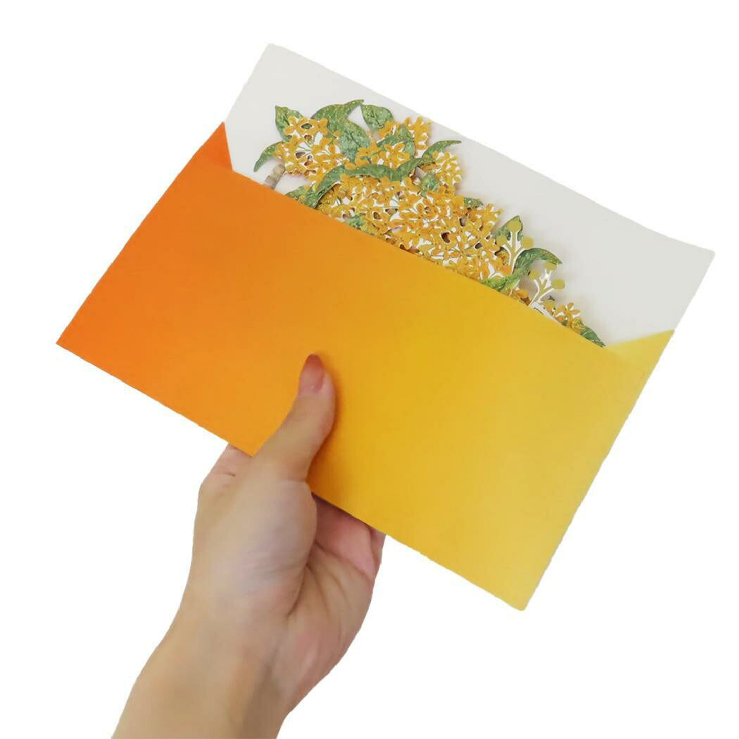 Hand holding a yellow card with an orange envelope featuring floral design on a white background