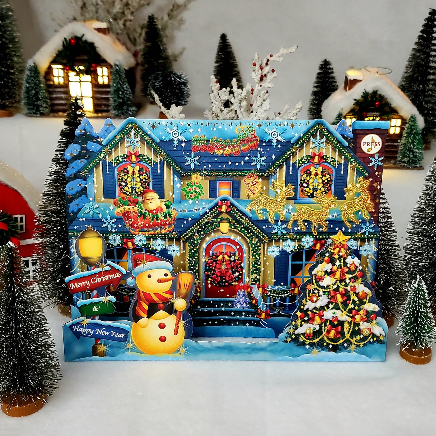 Interactive Christmas card with 3D illuminated house displayed on a holiday table.