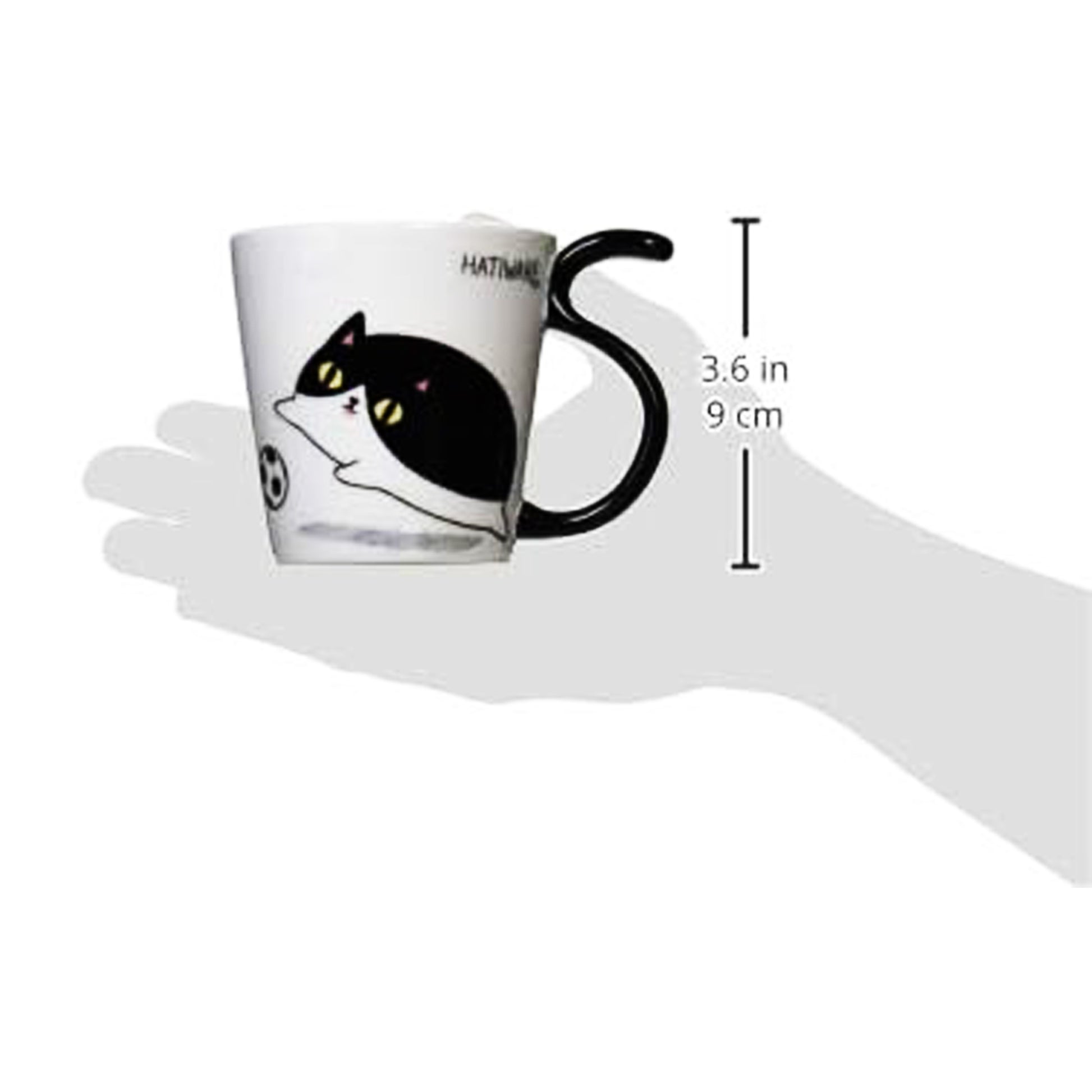 Mug with a cat design held by a hand, showing measurements.
