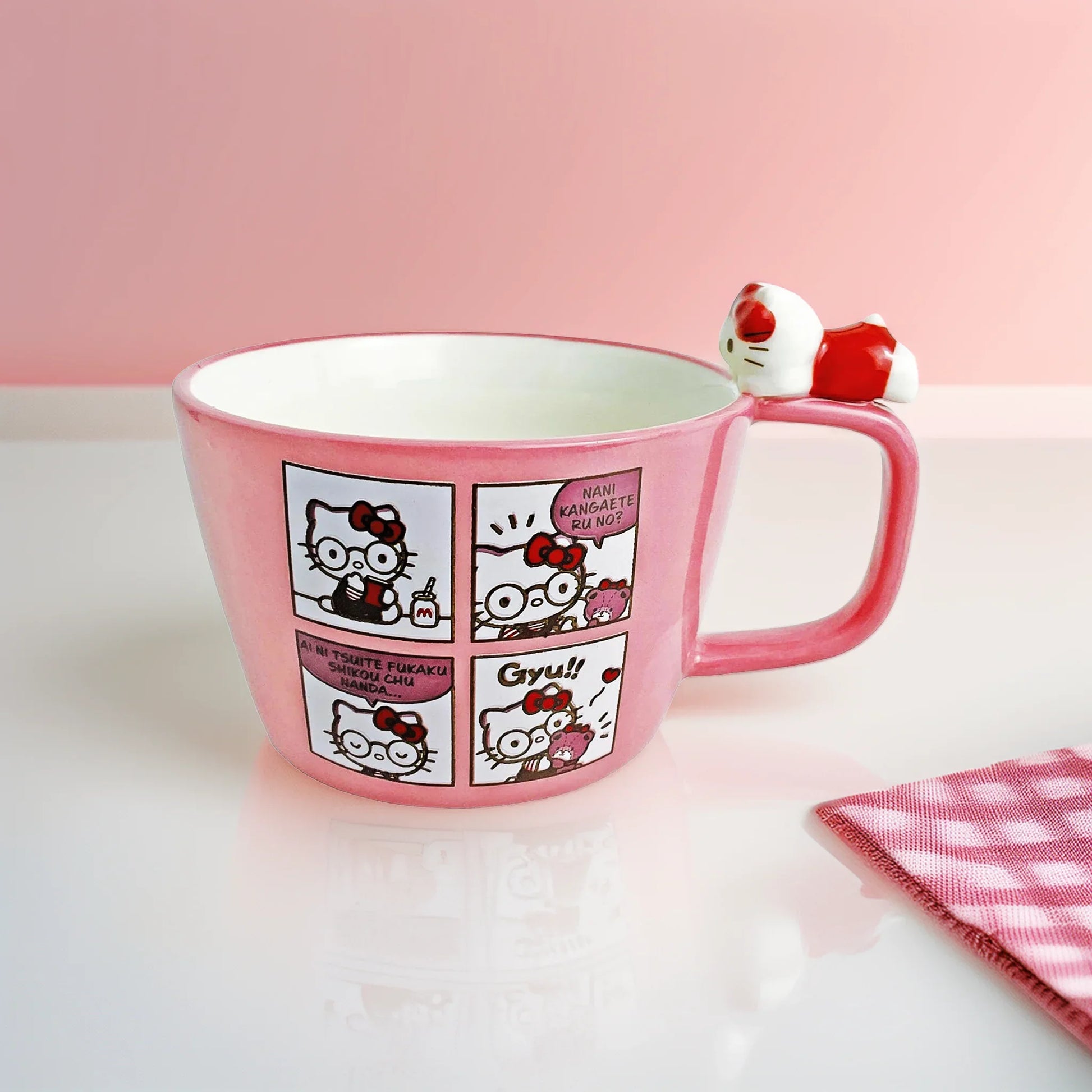 Pink mug with Hello Kitty character design on a white surface with a pink background