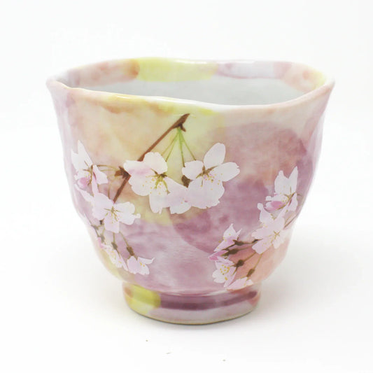 Side view of Hanagasumi Mino Ware Yunomi teacup featuring soft pink and yellow hues with delicate cherry blossom branches, made in Japan.