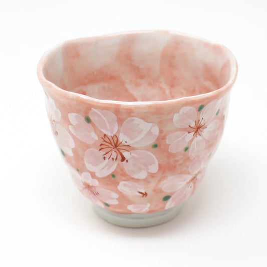Top angle of pink Japanese porcelain teacup with delicate cherry blossom design