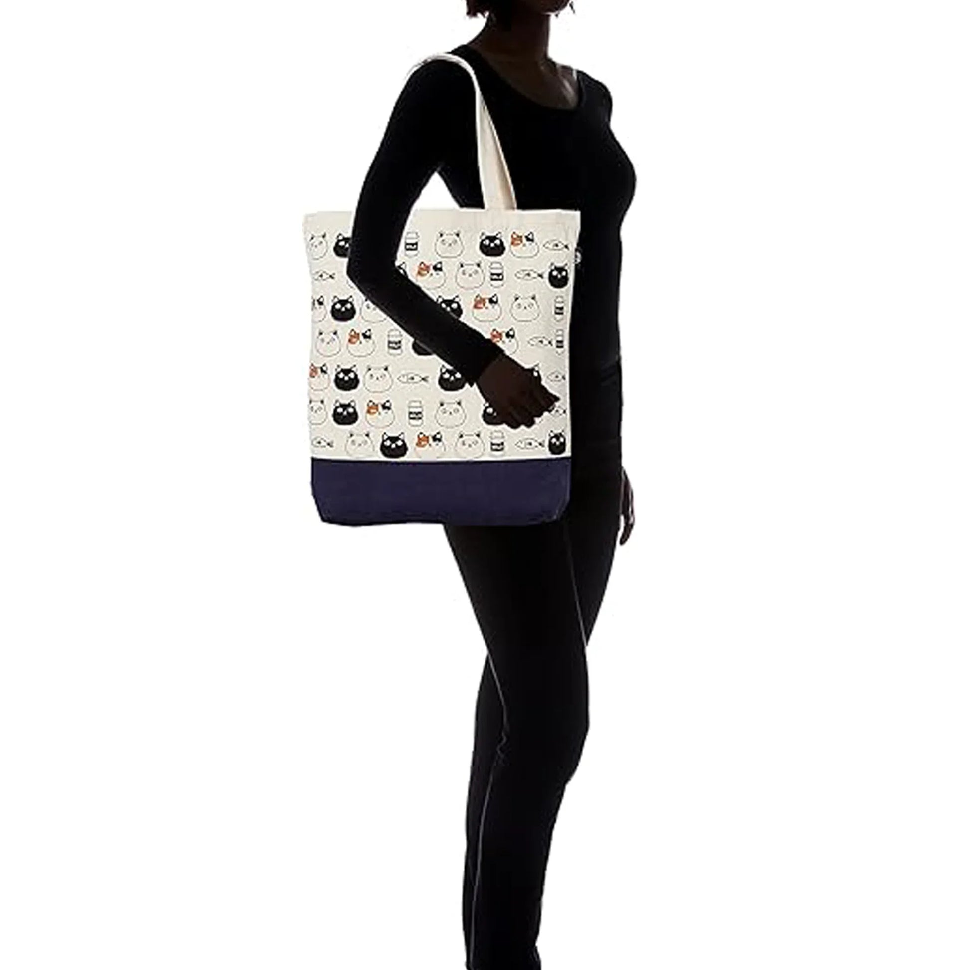 Person holding a tote bag with cat designs on a white background