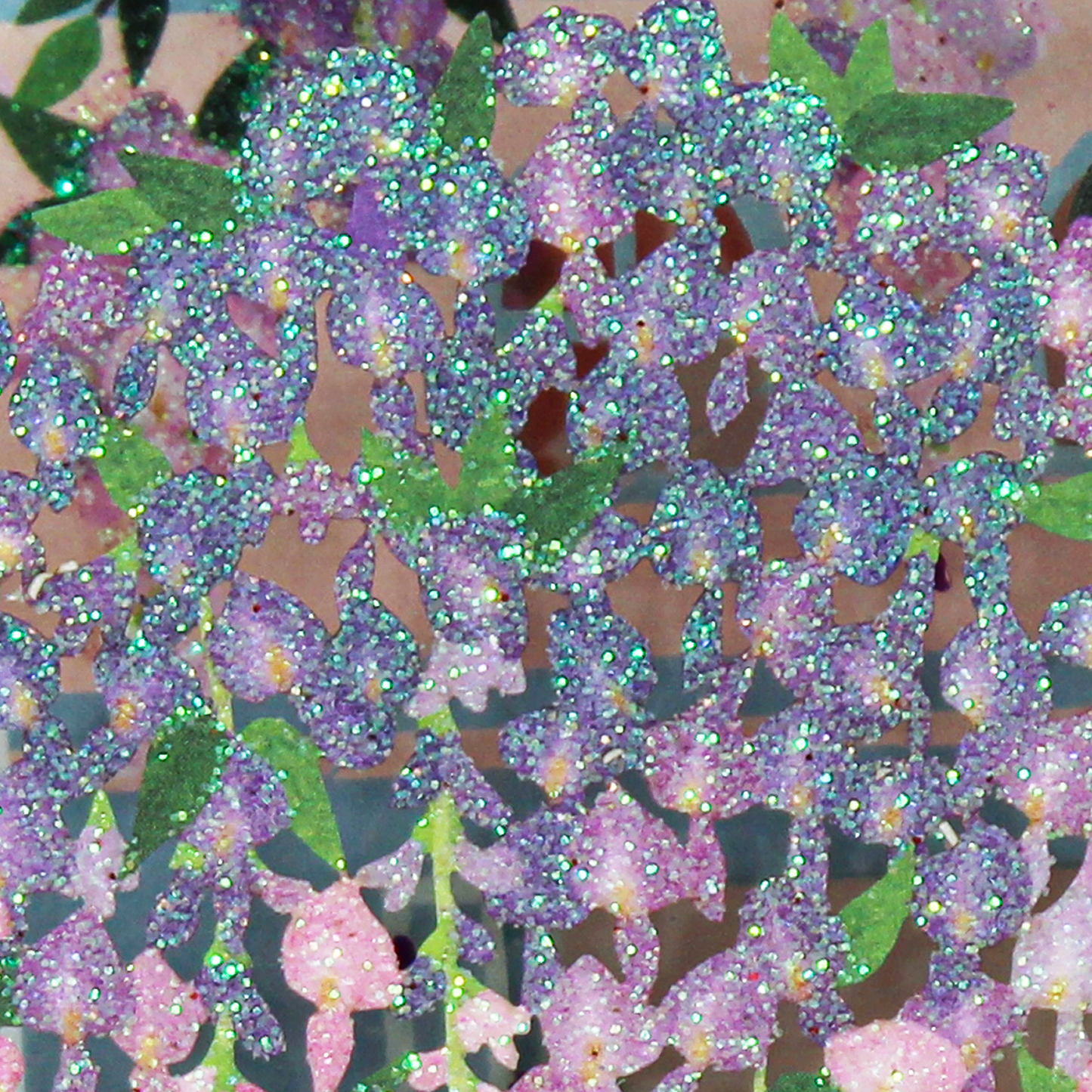 Close up of sparkling multicolor glitter on the laser cut wisteria flowers