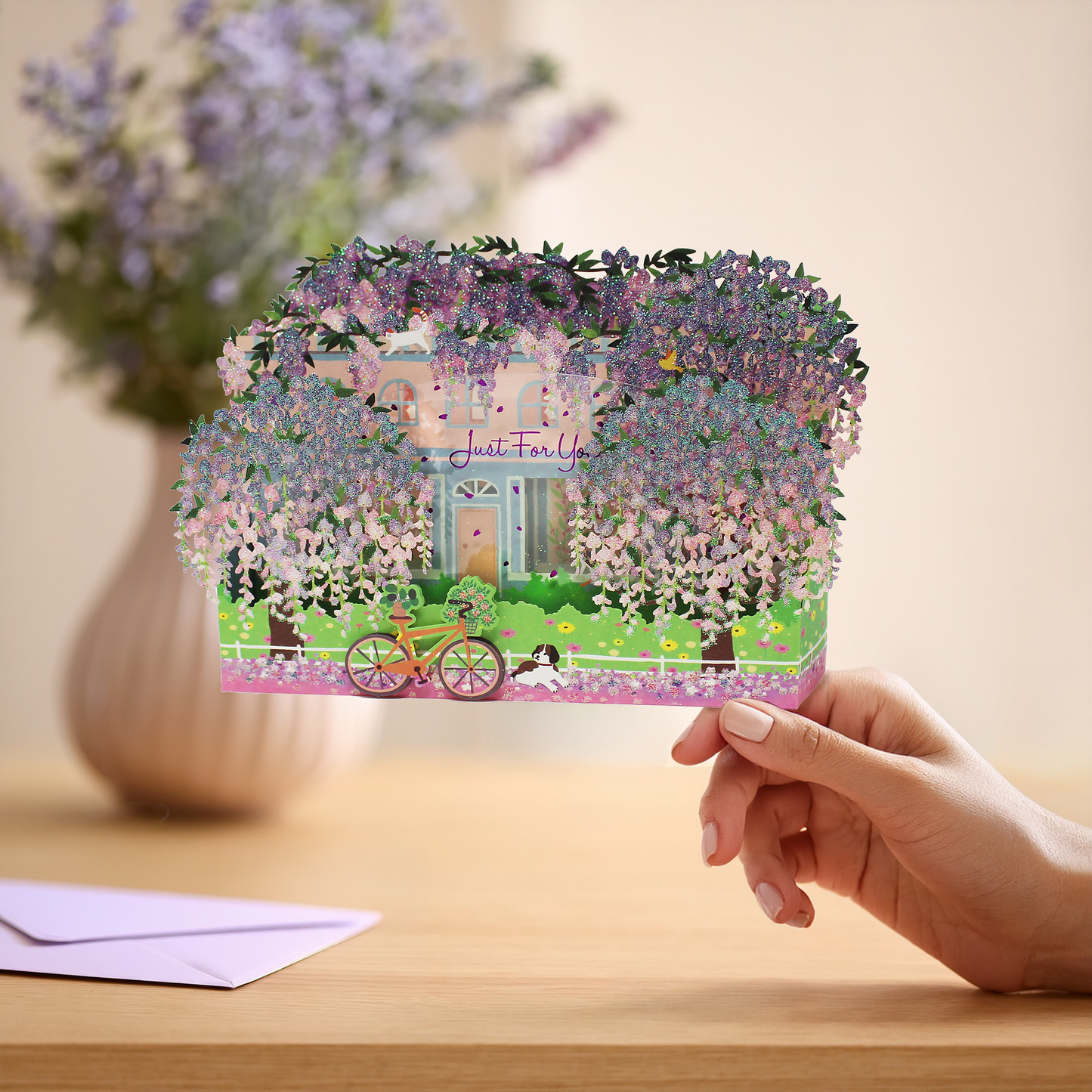 Wisteria 3D pop up greeting card held in hand with matching light purple envelope